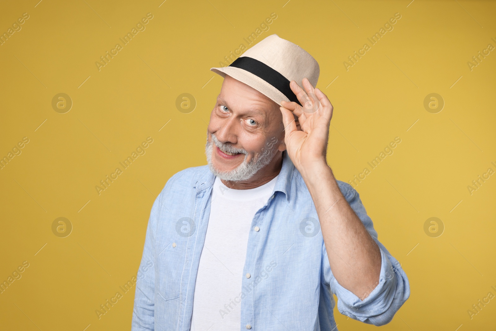 Photo of Portrait of happy senior man on yellow background