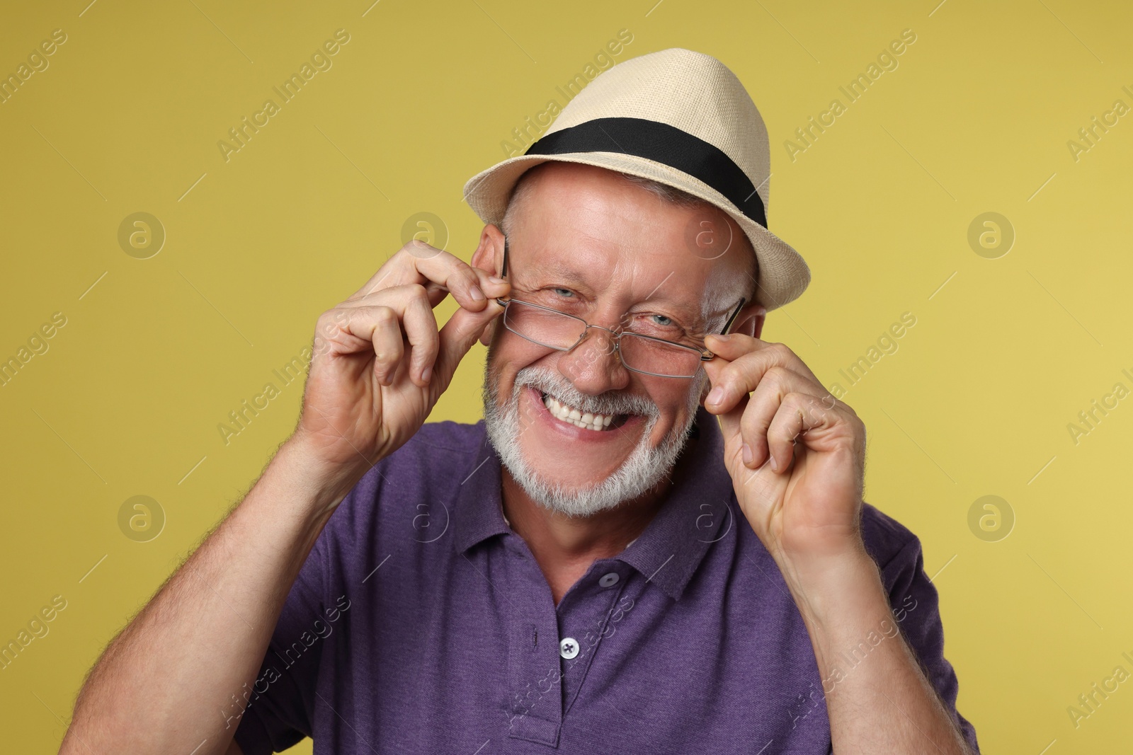 Photo of Portrait of happy senior man on yellow background