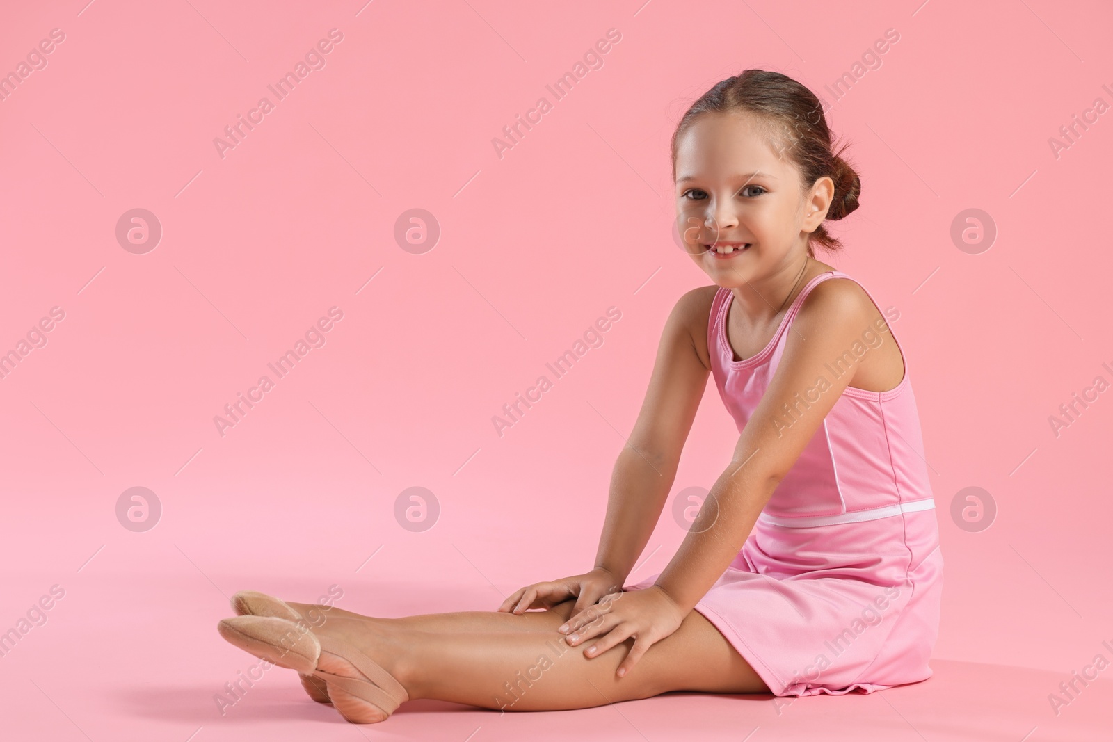 Photo of Portrait of little ballerina on pink background