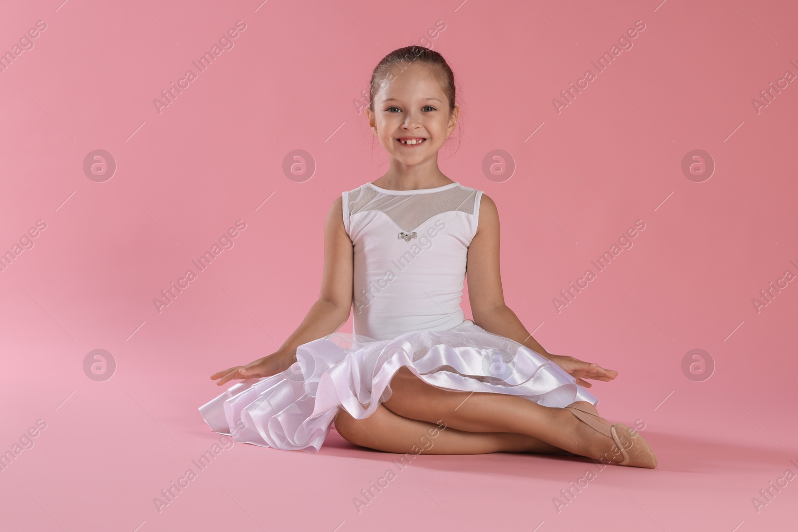 Photo of Portrait of little ballerina on pink background