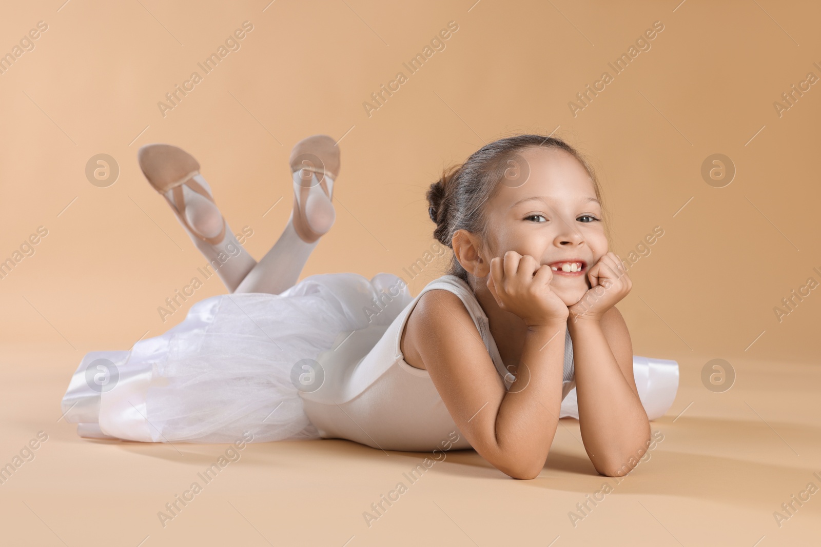 Photo of Portrait of little ballerina on beige background