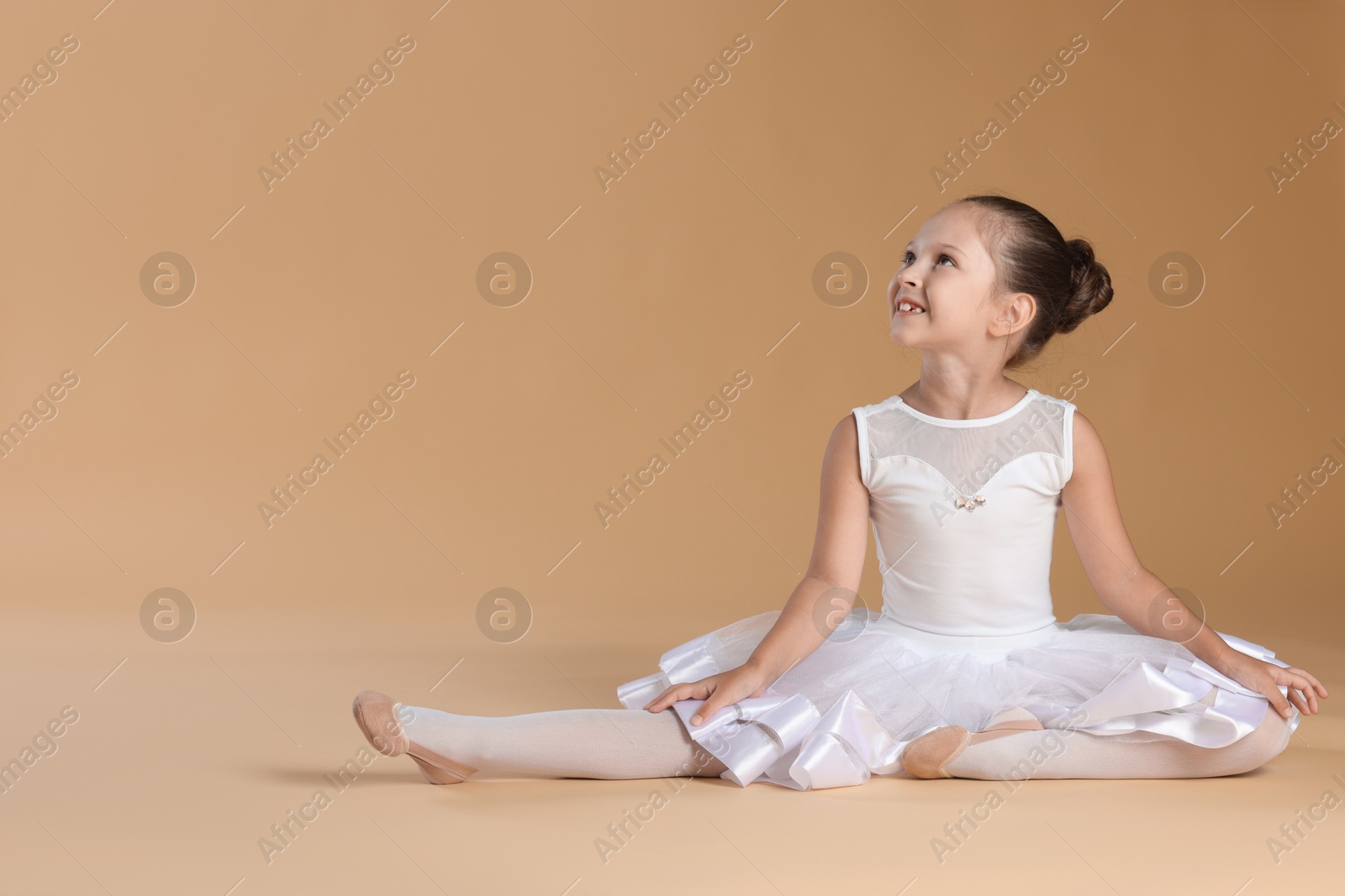 Photo of Portrait of little ballerina on beige background