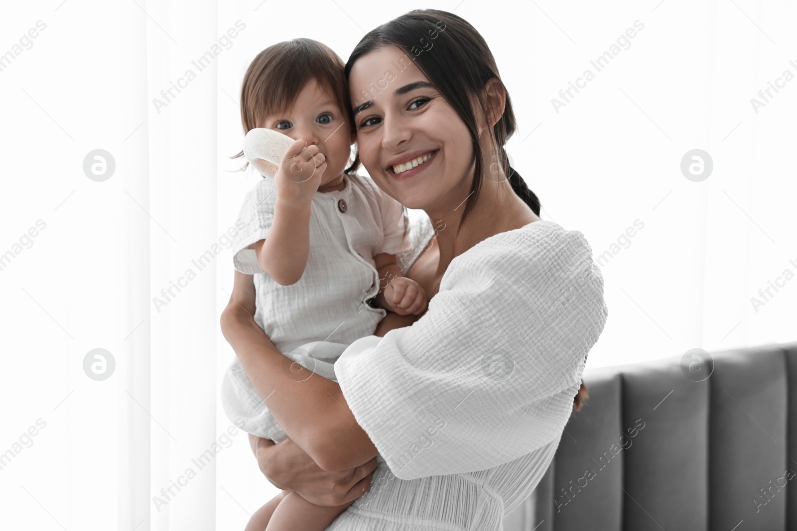 Photo of Beautiful young mother with her cute little baby indoors