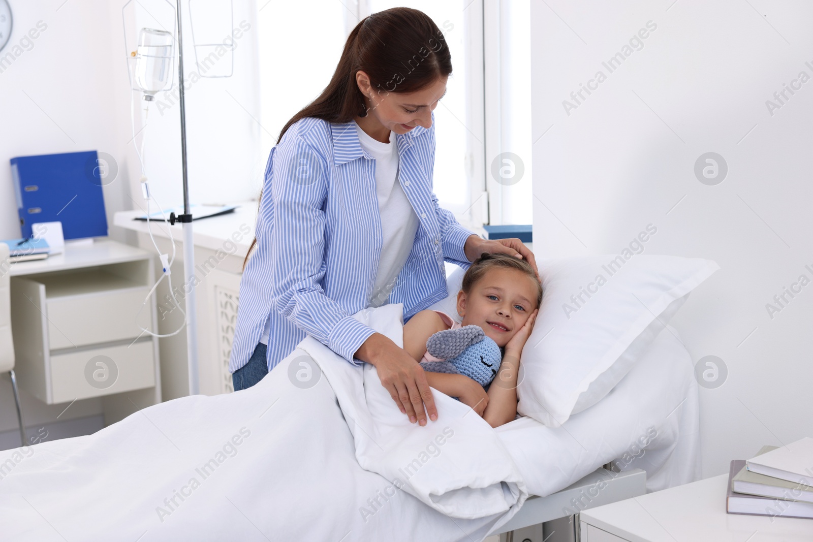 Photo of Mother and her little daughter on bed in hospital