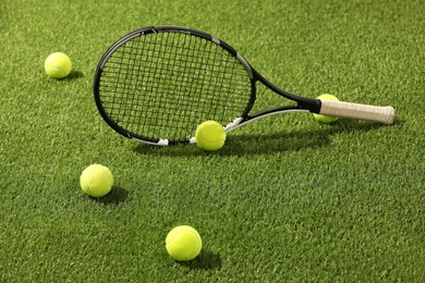 Photo of Tennis racket and balls on green artificial grass