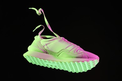 Stylish sneaker in air against dark background in neon lights