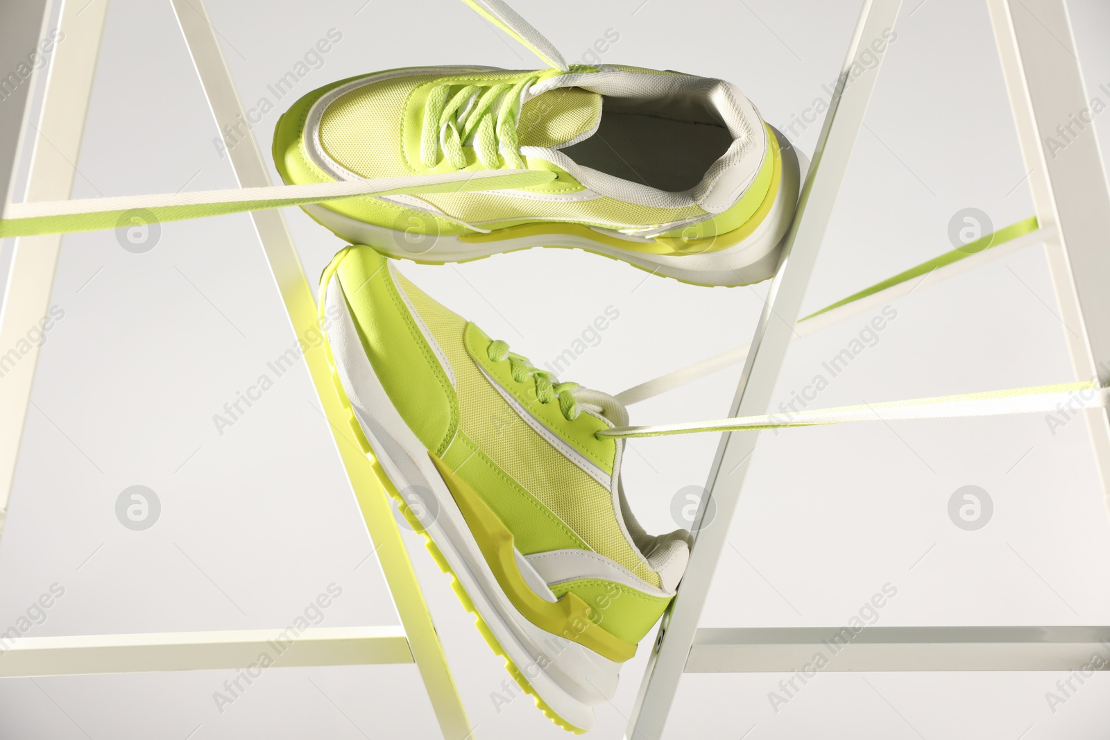 Photo of Stylish presentation of sneakers against white background