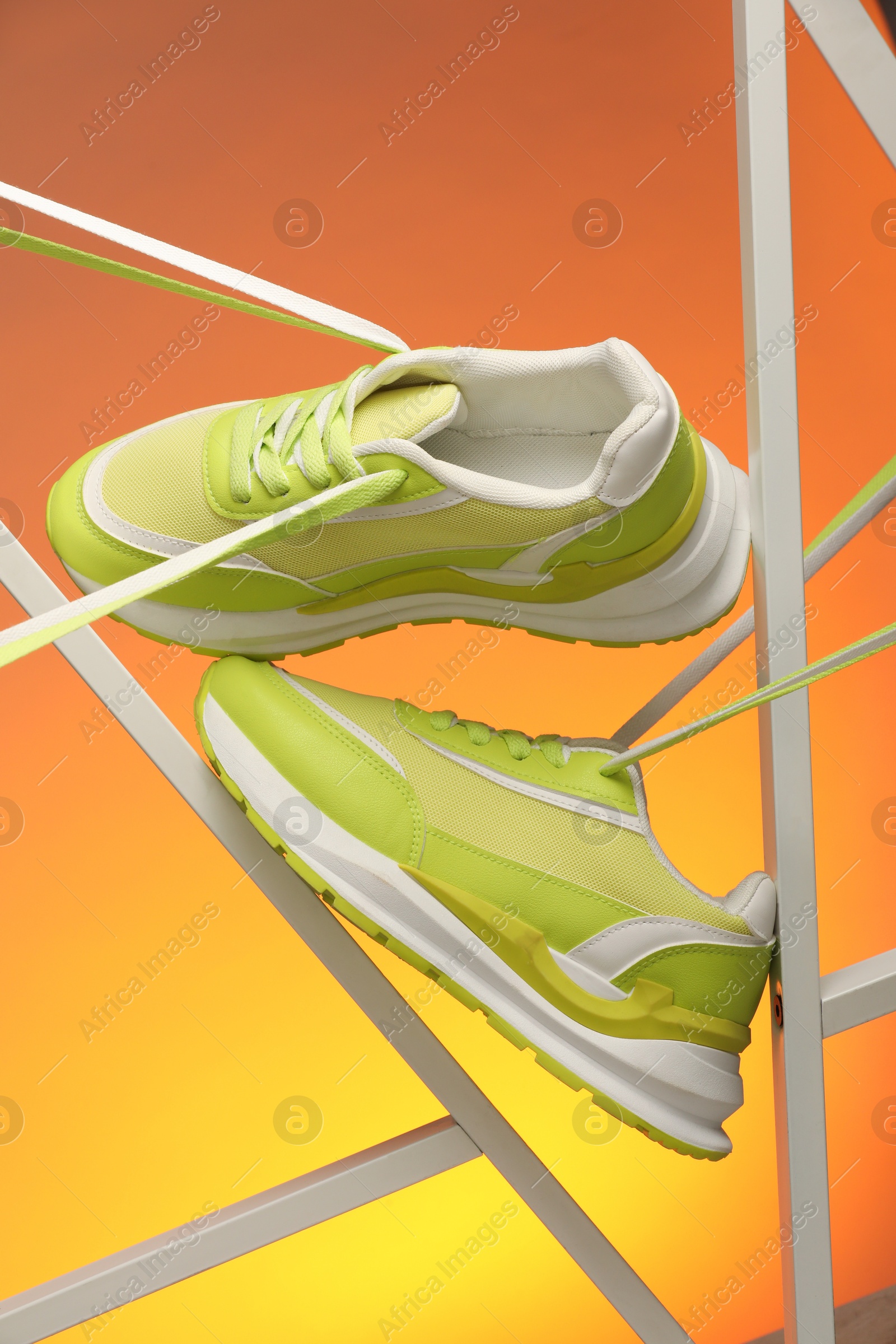 Photo of Stylish presentation of sneakers against color background