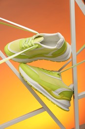 Stylish presentation of sneakers against color background