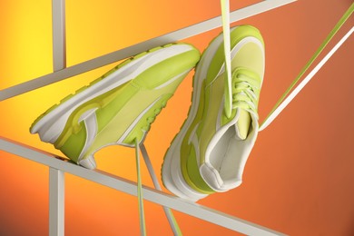 Photo of Stylish presentation of sneakers against color background