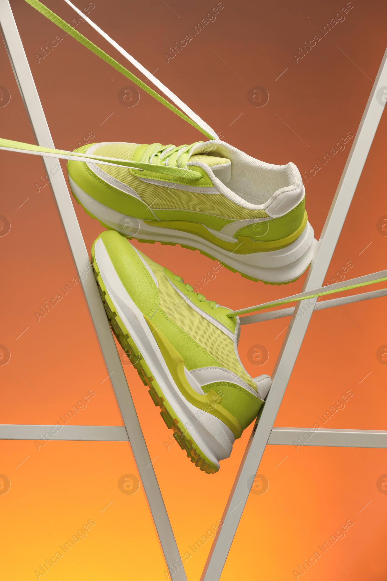 Photo of Stylish presentation of sneakers against color background