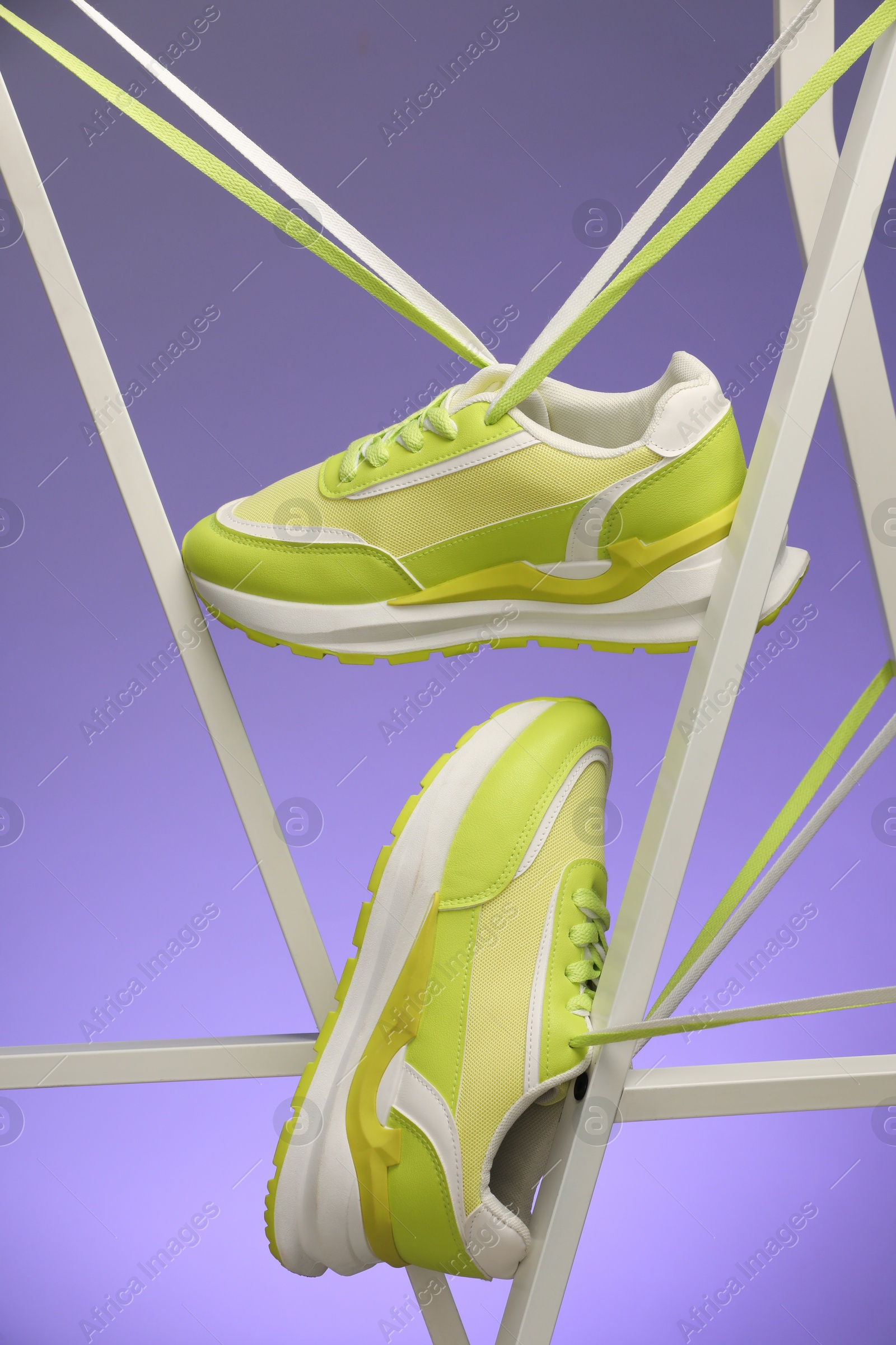 Photo of Stylish presentation of sneakers against color background