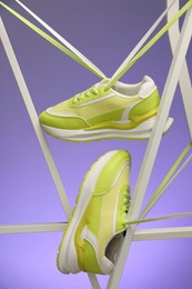 Stylish presentation of sneakers against color background