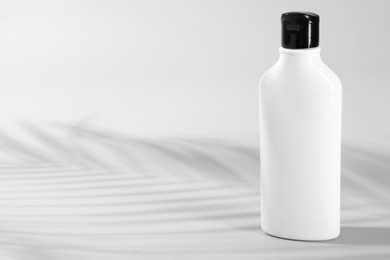 Photo of Bottle of shampoo on light background. Space for text