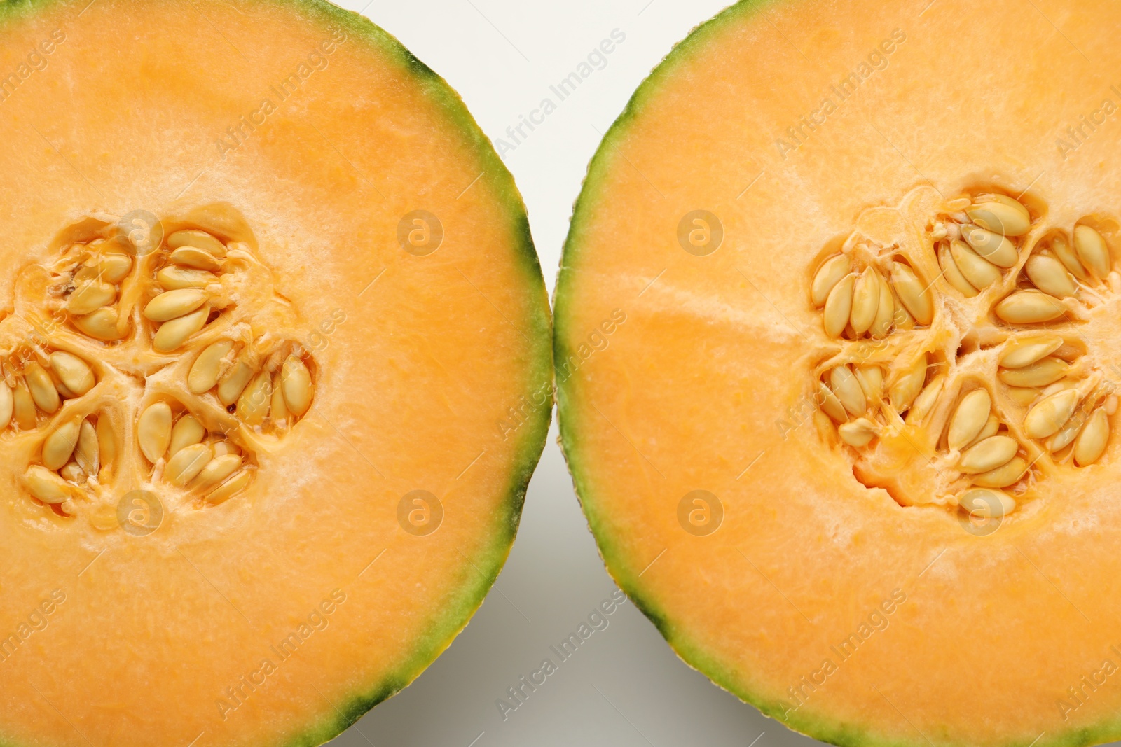 Photo of Halves of Cantaloupe melon on white table, top view