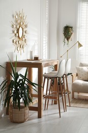 Photo of Bar stools near wooden table in room