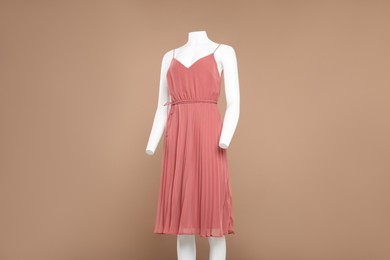 Photo of Female mannequin with stylish dress on light brown background