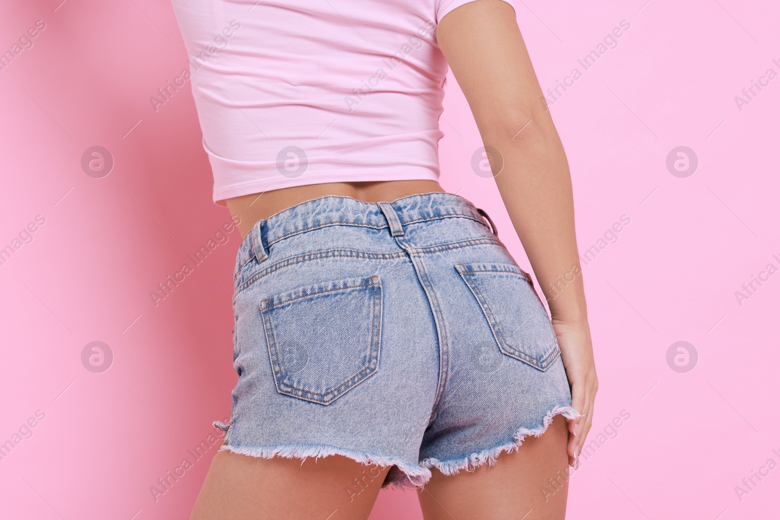 Photo of Woman wearing stylish denim shorts on pink background, closeup