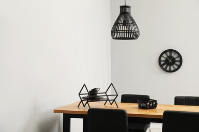 Photo of Wooden table with black chairs in stylish dining room