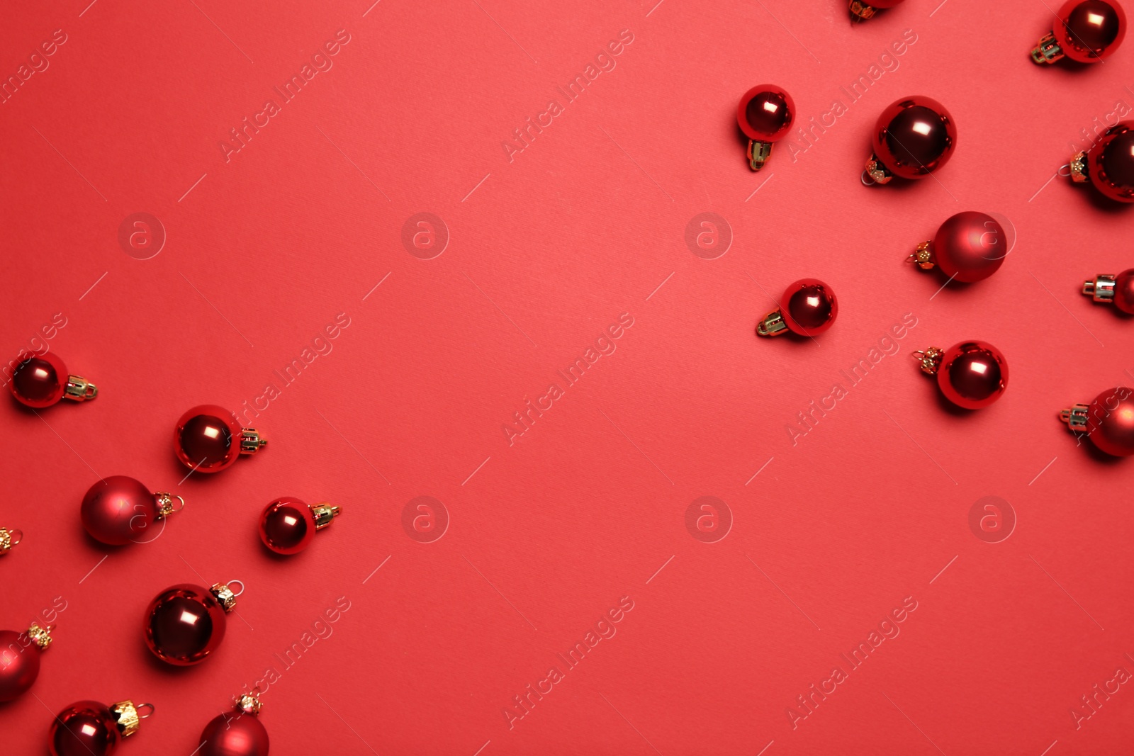 Photo of Christmas balls on red background, flat lay. Space for text