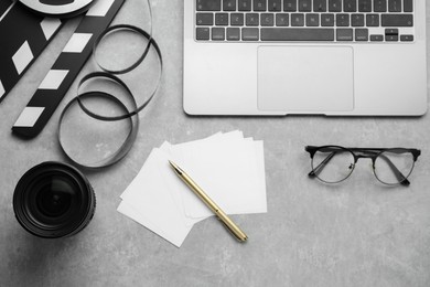 Photo of Flat lay composition with camera lens and laptop on grey textured table