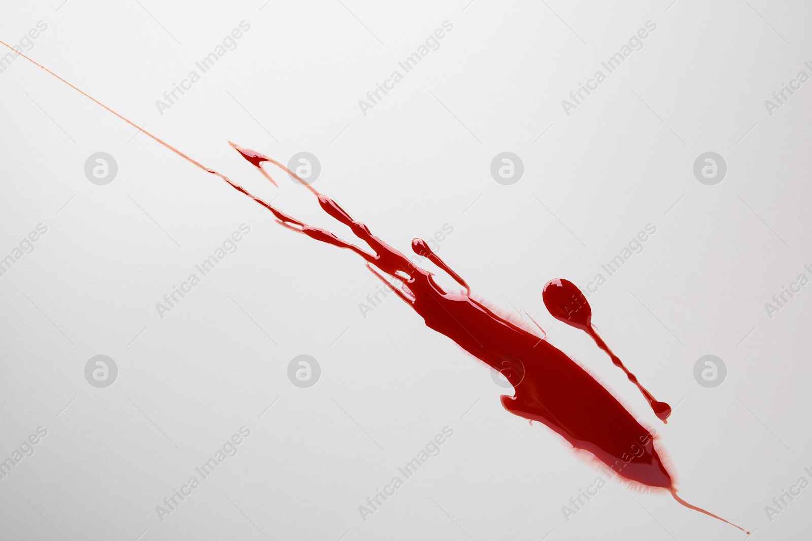 Photo of Splash of red blood on light background