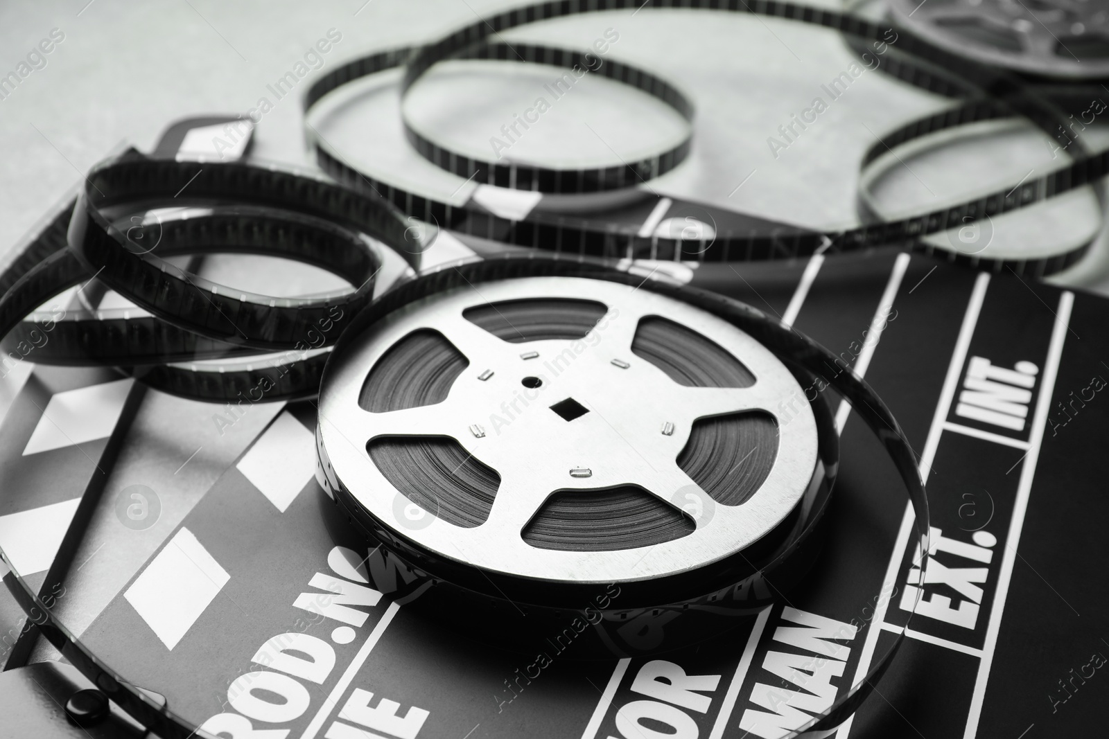 Photo of Movie clapper and film reel on table, closeup