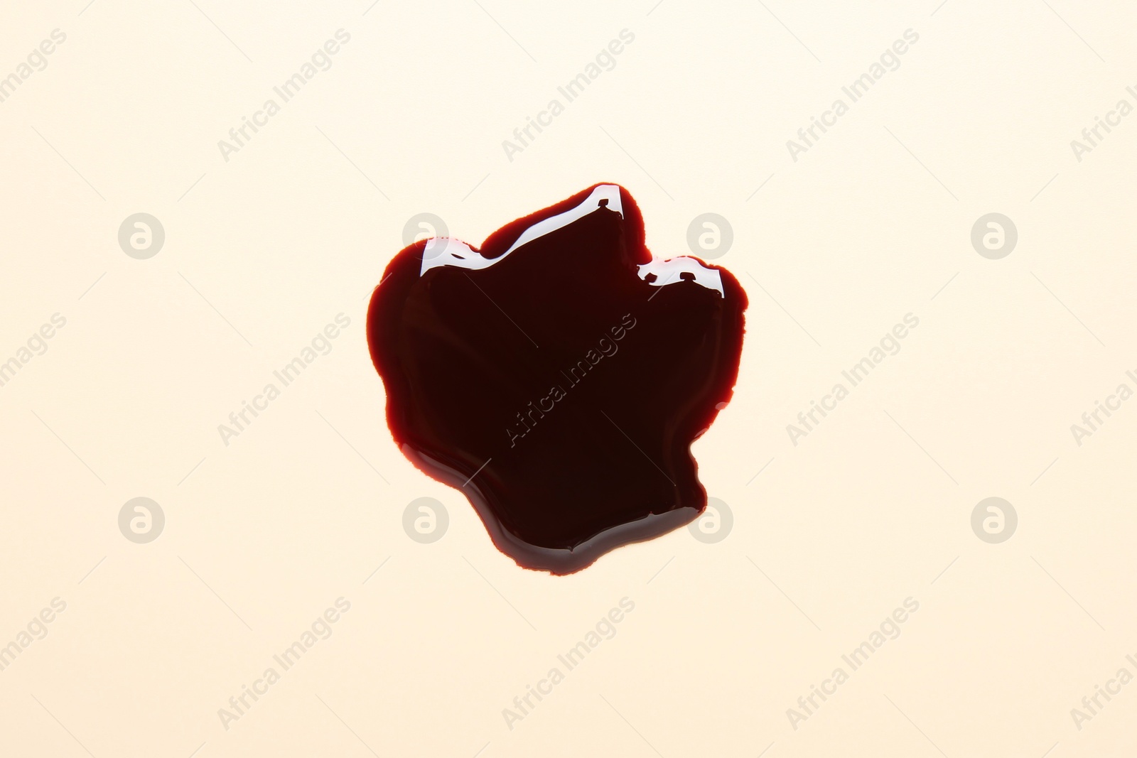 Photo of Stain of blood on beige background, top view