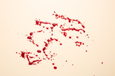 Photo of Splashes of blood on beige background, top view