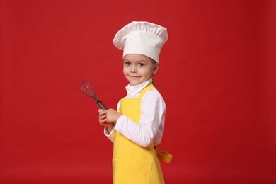 Photo of Little girl with whisk pretending to be chef on red background. Dreaming of future profession