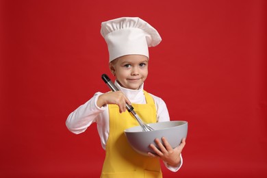 Photo of Little girl with bowl and whisk pretending to be chef on red background. Dreaming of future profession