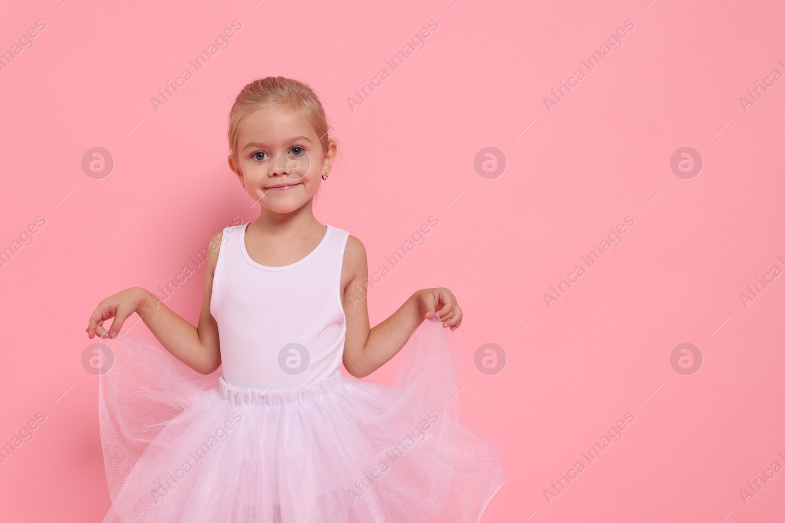 Photo of Little girl pretending to be ballerina on pink background, space for text. Dreaming of future profession