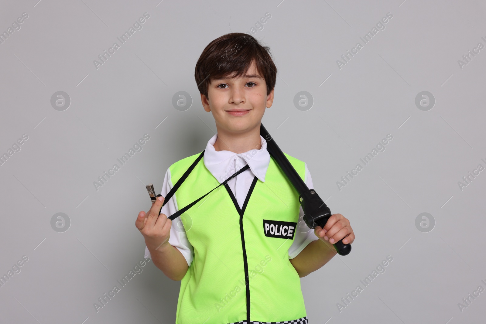 Photo of Boy pretending to be policeman on light grey background. Dreaming of future profession