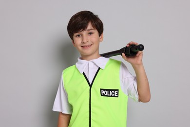 Photo of Boy pretending to be policeman on light grey background. Dreaming of future profession