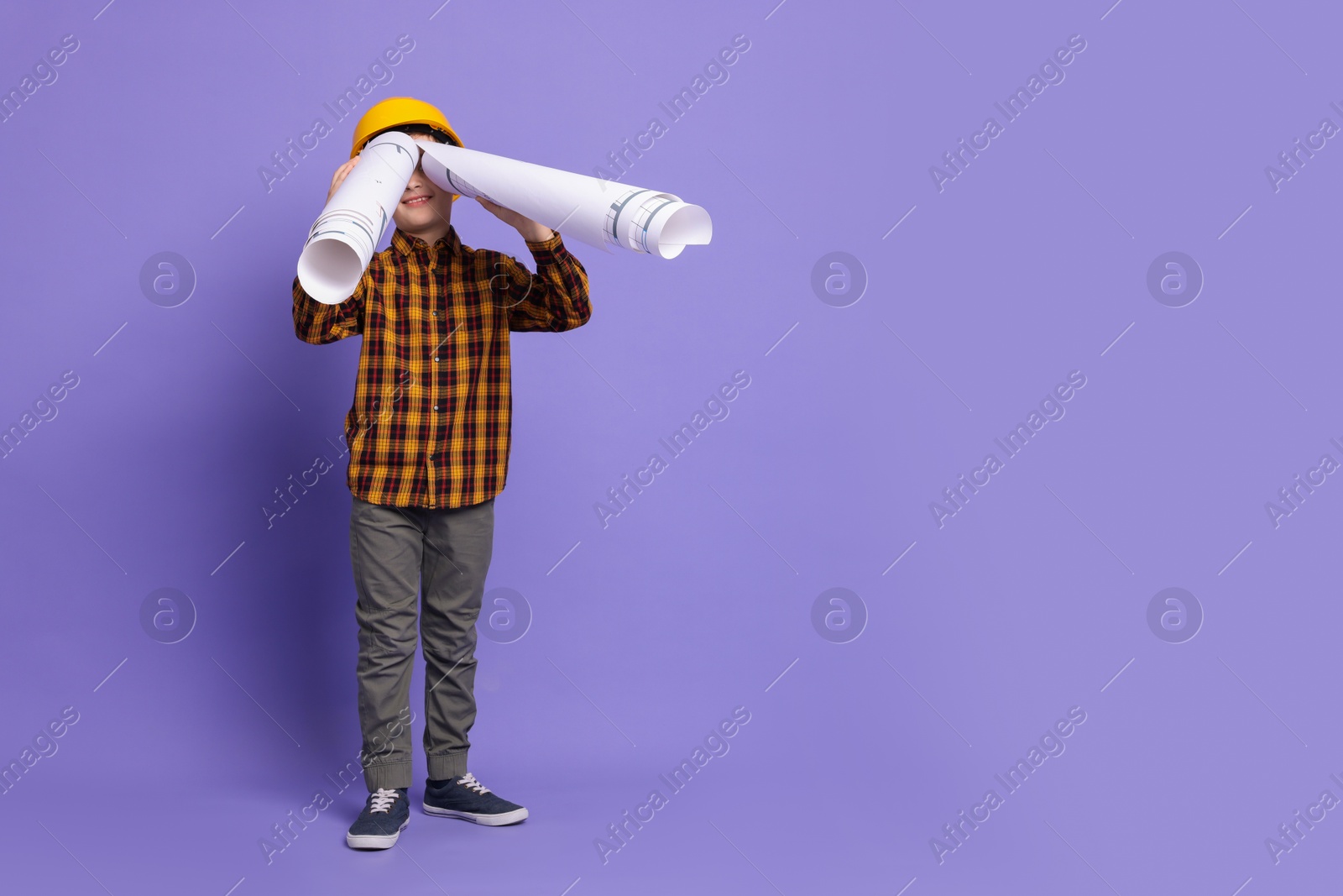 Photo of Boy with house plan pretending to be architect on violet background, space for text. Dreaming of future profession