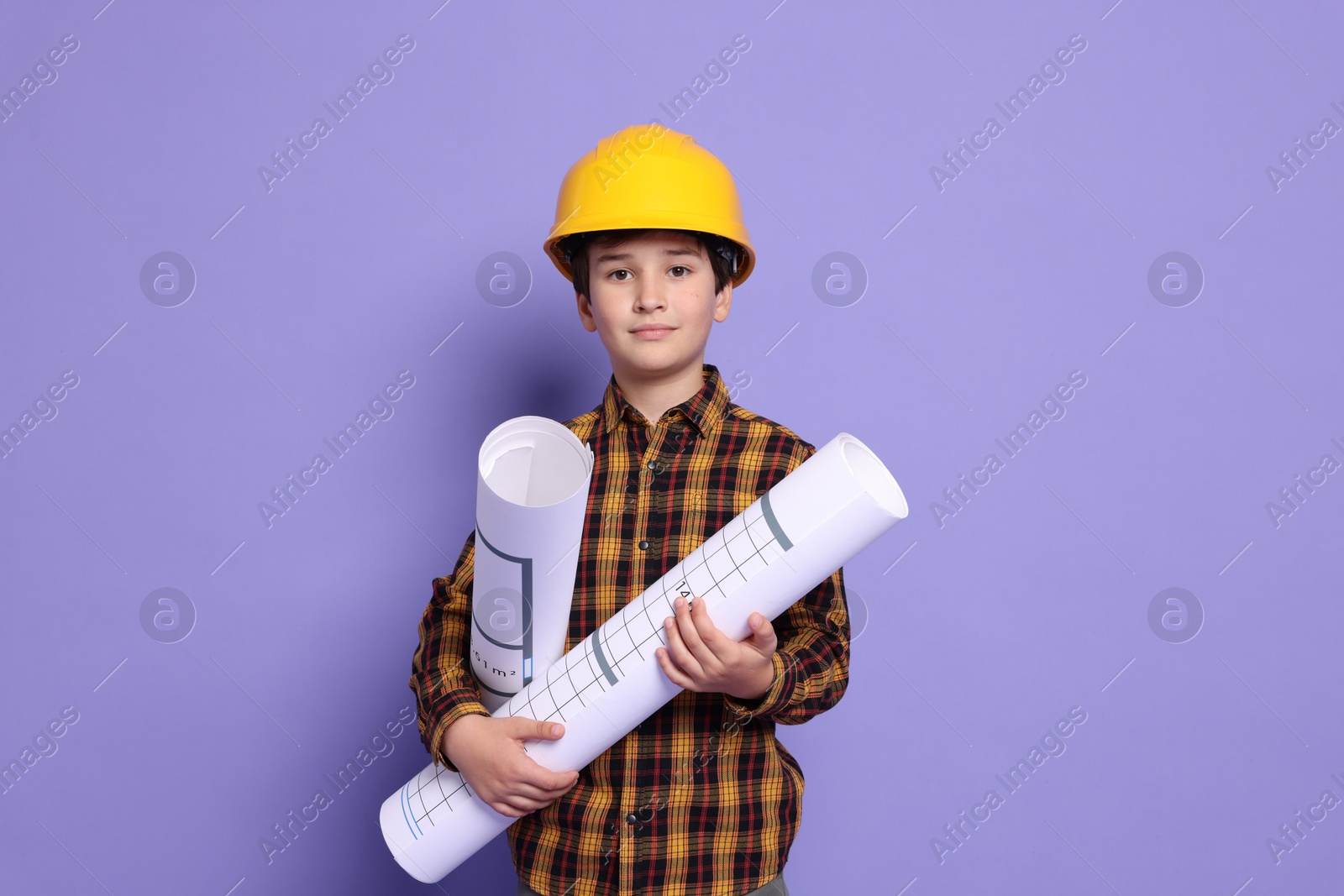 Photo of Boy with house plan pretending to be architect on violet background. Dreaming of future profession