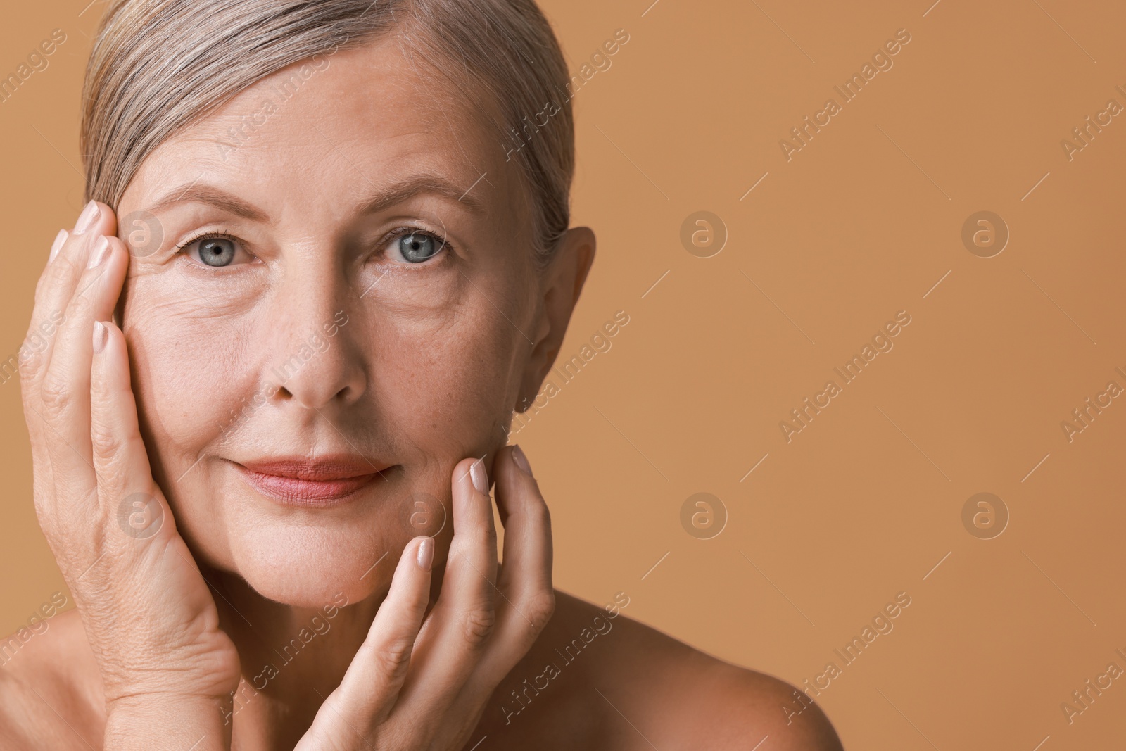 Photo of Face massage. Beautiful woman with healthy skin on beige background, closeup. Space for text