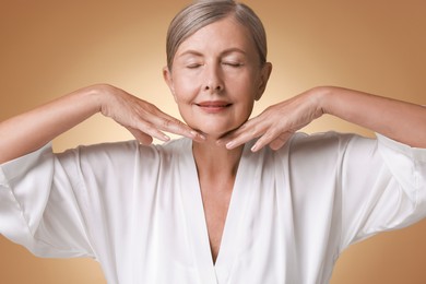 Face massage. Beautiful woman with healthy skin on beige background