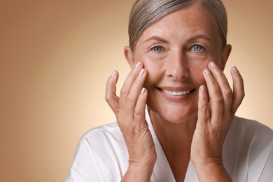 Photo of Face massage. Beautiful woman with healthy skin on beige background