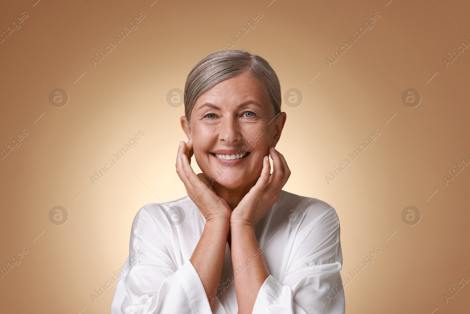 Photo of Face massage. Beautiful woman with healthy skin on beige background