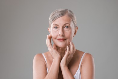 Face massage. Beautiful woman with healthy skin on grey background