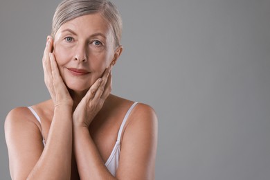 Photo of Face massage. Beautiful woman with healthy skin on grey background, space for text