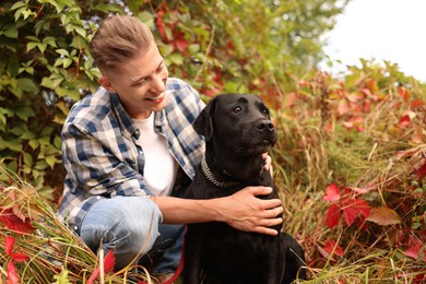 Smiling man with cute dog outdoors on autumn day