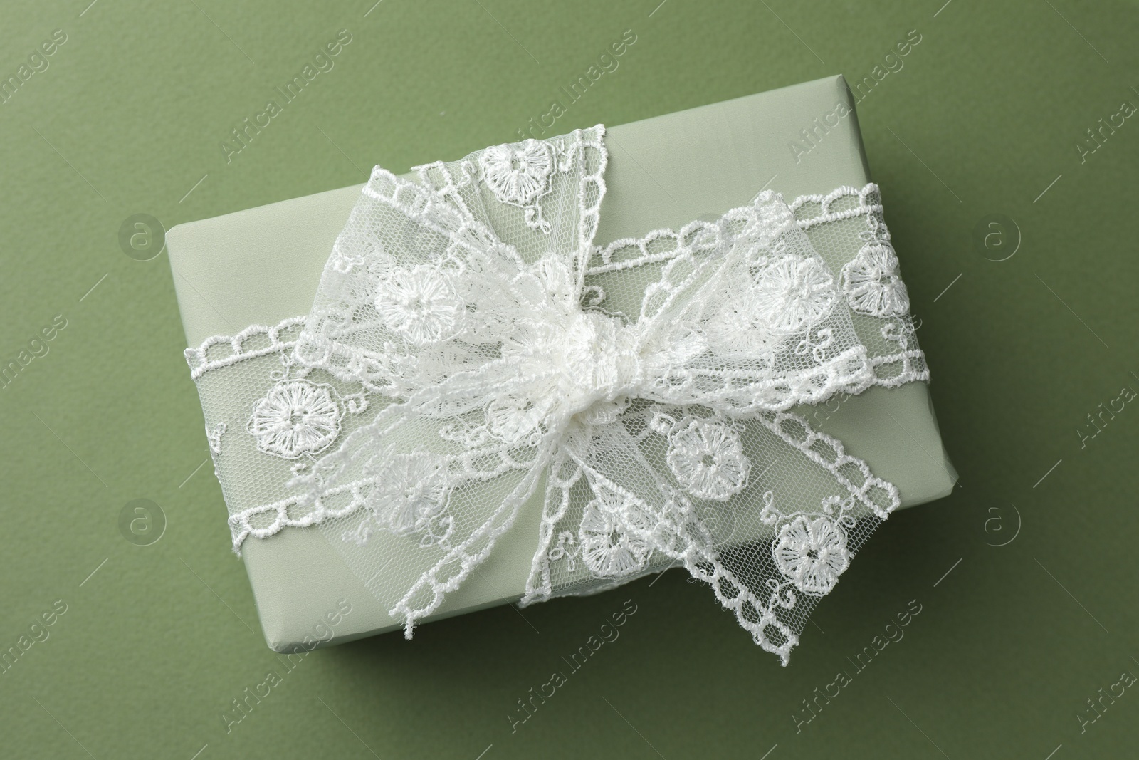 Photo of Gift box with bow on green background, top view