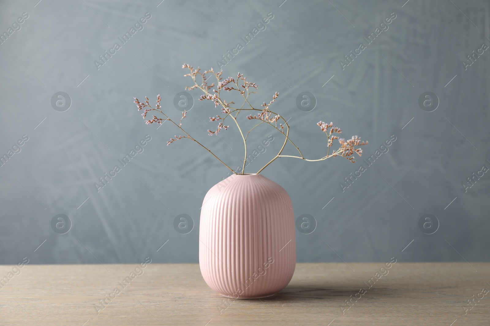 Photo of Stylish vase with beautiful branches on wooden table