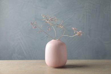 Photo of Stylish vase with beautiful branches on wooden table