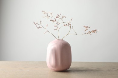 Photo of Stylish vase with beautiful branches on wooden table