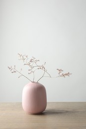 Stylish vase with beautiful branches on wooden table