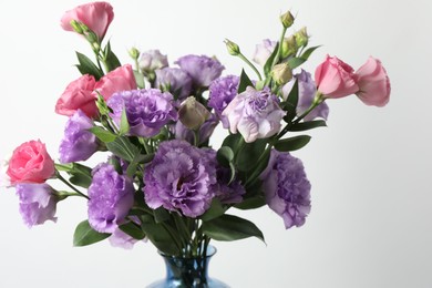 Beautiful eustoma flowers in vase on light background, closeup