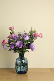 Vase with beautiful eustoma flowers on wooden table